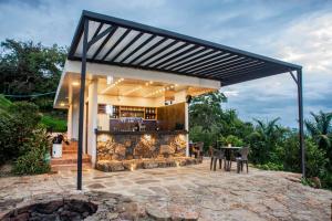 een paviljoen met een tafel en stoelen op een patio bij Glamping Luxury vista infinita y Jaccuzi en Sangil in San Gil
