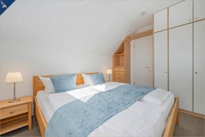 a bedroom with a large bed with blue pillows at Ferienanlage Seeblick Aquamarin in Ostseebad Koserow