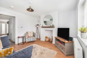 uma sala de estar com uma televisão e um sofá em Puddle Duck Cottage em Cranswick