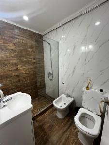 a bathroom with a toilet and a sink and a shower at Departamento Plaza Colón Yeyita in Mar del Plata