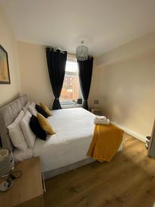 1 bed Flat ''Beta'' in Dewsbury road, Leeds في Hunslet: غرفة نوم بسرير ابيض كبير واريكة