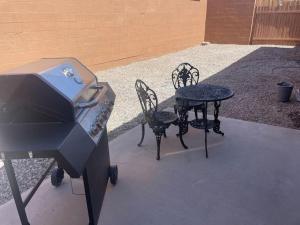 a bbq and a table and chairs next to a grill at Hopi Keys House in Parker