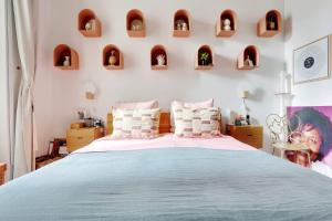 - une chambre avec un grand lit et des étagères murales dans l'établissement Very nice apartment Atypical 6 People, à Paris