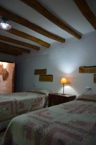 - 2 lits dans une chambre dotée de poutres en bois dans l'établissement Vivienda Rural El Peñón de Los Primillas, à La Iruela