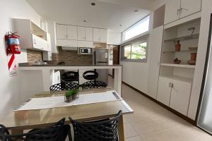a kitchen with white cabinets and a table and chairs at Tango Apartment, p/ 4 personas, con cochera. in Salta
