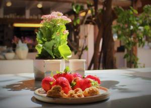 un plato de fresas sentado en una mesa en Luksus i lønstrup, med kunsten i hovedfokus M en Lønstrup