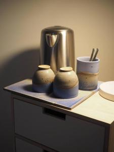 una mesa con dos cuencos pequeños y una jarra en Luksus i lønstrup, med kunsten i hovedfokus M en Lønstrup