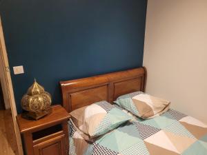 1 dormitorio con cama y pared azul en Les Forsythias en Messeix