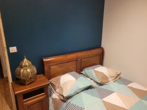 a bedroom with a bed and a blue wall at Les Forsythias in Messeix