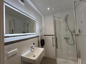 a white bathroom with a sink and a shower at Apartment Düsseldorf City in Düsseldorf