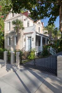 una vecchia casa con una recinzione di fronte di The Courtyard at CasaZoe a Charleston