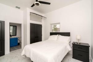 a white bedroom with a bed and a ceiling fan at Perfect Spacious Modern Home w/Hot Tub in San Antonio