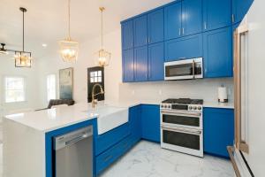 a kitchen with blue cabinets and white counter tops at Perfect Spacious Modern Home w/Hot Tub in San Antonio