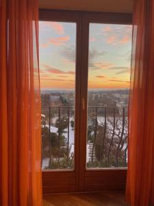 an open window with a view of a winter landscape at Herrlicher Ausblick über Wien in Vienna