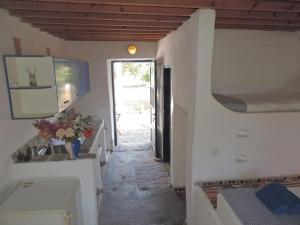 um corredor com paredes brancas e um corredor com uma porta em Lovely independent room in Ecovilla on the beach em Apolakkiá