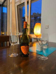 a bottle of wine sitting on a table with two glasses at Apartments Skyreach in Essen