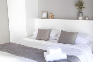a white bed with white sheets and pillows at Charlie Suites en el casco histórico de Salta in Salta