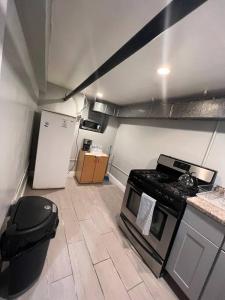 uma pequena cozinha com um fogão e um frigorífico em The Legato Suite em Brooklyn