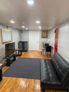 un soggiorno con divano nero e tavolo di The Legato Suite a Brooklyn
