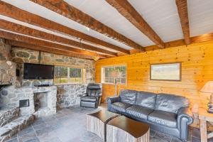 a living room with a couch and a fireplace at Dog-Friendly 3BR on 200 Acres w/ River Access in Sloat