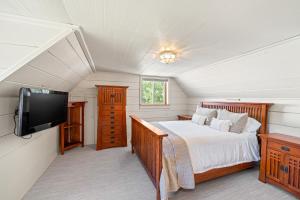 a bedroom with a bed and a flat screen tv at Dog-Friendly 3BR on 200 Acres w/ River Access in Sloat