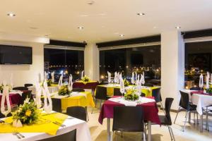 a dining room with tables with yellow and white tablecloths at Isa Victory Hotel Boutique in Armenia