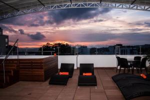 een dakterras met stoelen en een tafel met een zonsondergang bij Isa Victory Hotel Boutique in Armenia