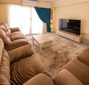 a living room with couches and a flat screen tv at luxury Heliopolis gem in Cairo