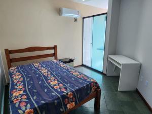 1 dormitorio con cama, escritorio y ventana en Prainha- Apart 2 quartos a 1 min da praia!, en Arraial do Cabo