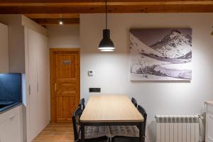 a dining room with a wooden table and chairs at AndBnB l Junto a GrandValira con Parking Gratuito in Incles