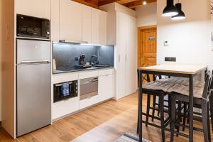 a kitchen with a stainless steel refrigerator and a table at AndBnB l Junto a GrandValira con Parking Gratuito in Incles