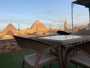 a table and chairs with a view of the pyramids at black pyramids view in Cairo