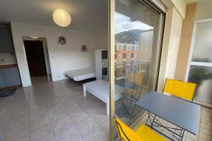 um quarto com uma varanda com uma mesa e cadeiras amarelas em 06BQ Studio close to the beach em Roquebrune-Cap-Martin