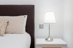 a bedroom with a bed with a lamp on a night stand at AndBnB I Refugio sobre el Río, Esquí y Parking gratis in Ransol