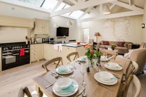 een keuken en een woonkamer met een tafel en stoelen bij Williamston Cowshed in Slaggyford