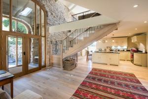 eine offene Küche und ein Wohnzimmer mit einer Treppe in der Unterkunft Williamston Barn & Cowshed in Slaggyford