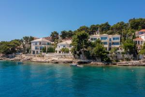 a group of houses on the shore of a body of water at Luxury Villa Bohemian 2 heated pool near sea in Selca