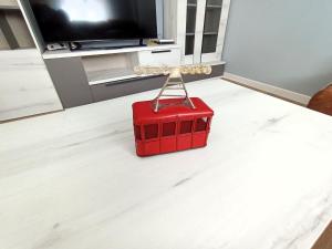una valigia rossa seduta sul pavimento in un soggiorno di Apartamento en Santander cercano al centro a Santander