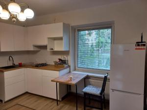 a kitchen with a table and a white refrigerator at Apartament Senator Stężyca in Stężyca