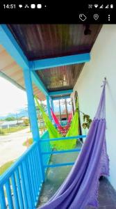 a porch with a hammock on a house at Pousada paraíso no Mar in Matinhos