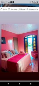a bedroom with pink walls and a bed in a room at Pousada paraíso no Mar in Matinhos