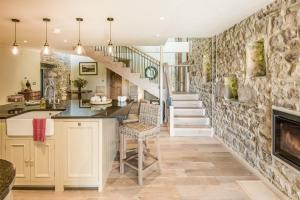 a kitchen with a staircase and a stone wall at Williamston Barn in Slaggyford +22 photos