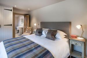 a bedroom with a large white bed and a desk at Williamston Barn in Slaggyford