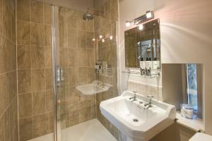 een badkamer met een wastafel en een douche bij Williamston Barn in Slaggyford