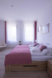 um quarto com uma cama grande e um cobertor rosa em Wagner Villa 902 em Budapeste