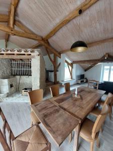 comedor con mesa de madera y sillas en Villa pierre campagne en Brassac