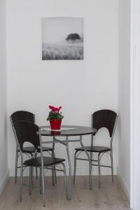 uma mesa com quatro cadeiras e uma planta sobre ela em Wagner Villa 902 em Budapeste