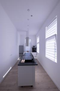 a white kitchen with a stove top island in a room at Wagner Villa 902 with free private parking in Budapest