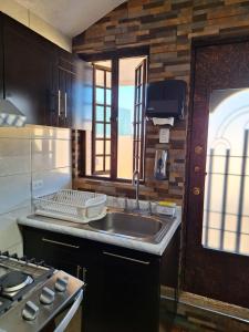 a kitchen with a sink and a stove at Bonita casa chica con amplio patio in Coatepec