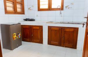 cocina con armarios de madera y nevera de acero inoxidable en JRéside Appart XL02 50m2 centre-ville, en Cotonou